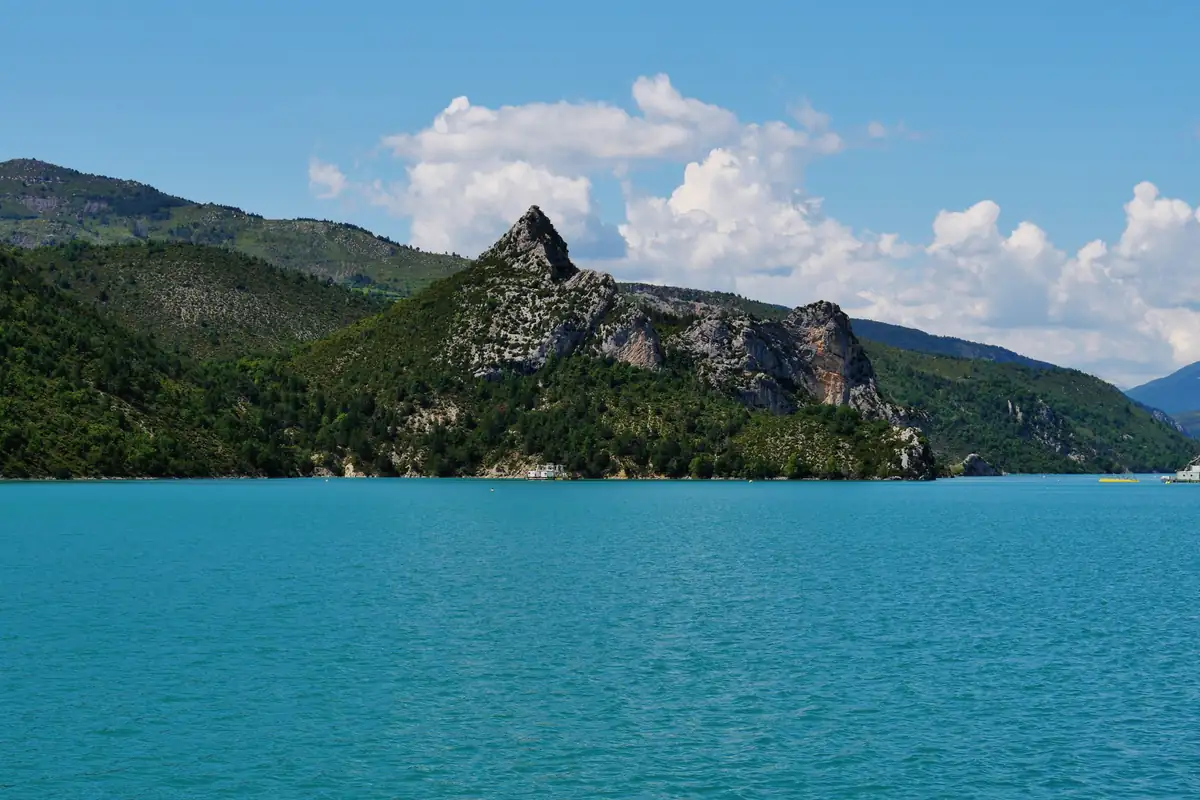 Le lac de Castillon, eaux turquoise au pied d'un sommet rocheux boisé